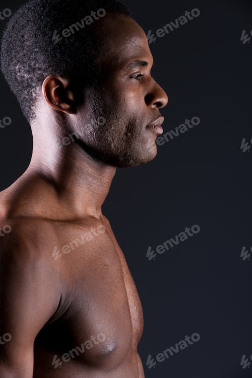 Preview: Masculinity. Side View Of Young African Man Looking Away While Standing Against Grey Background