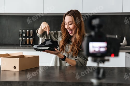 Preview: Happy Young Girl Recording Her Video Blog Episode About New Sneakers Shoes While Sitting At The