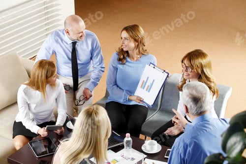 Preview: High Angle View Of Business Team In A Meeting. Businesswomen And Businessmen Sitting Around