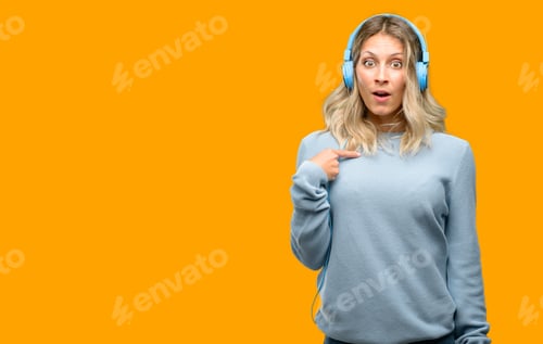 Preview: Young Beautiful Woman Listening To Music Happy And Surprised Cheering Expressing Wow Gesture