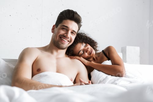 Preview: Beautiful Happy Young Multiethnic Couple Relaxing In Bed Under Blanket