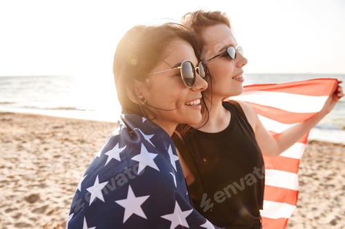 Vista previa: Image Of Cheerful Excited Women Friends Outdoors On The Beach Holding Usa Flag Having Fun.