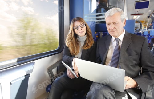 Preview: Portrait Of Two Businesspeople Traveling On Train. Middle Age Businesswoman Using Digital Tablet