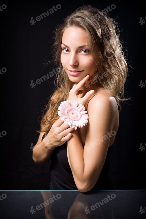Preview: Elegant, Moody Portrait Of Beautiful Young Brunette With Flower, On Black Background.