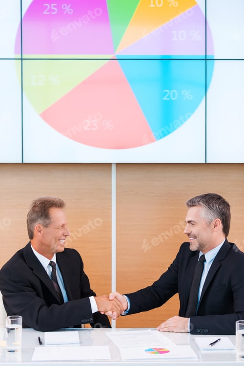 Preview: That Was Successful Year. Two Confident Business People In Formalwear Handshaking And Smiling While