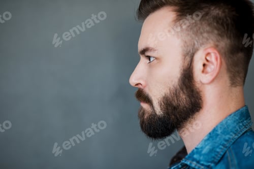 Preview: Serious And Confident. Side View Of Young Man Looking Away While Standing Against White Background