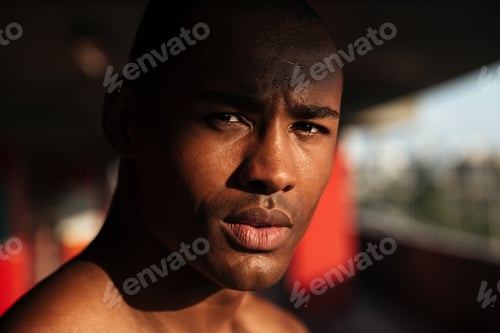 Preview: Close Up Portrait Of A Young Focused African Sportsman Looking At Camera Indoors