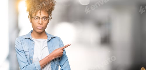 Preview: Beautiful Young African American Woman Wearing Glasses Over Isolated Background Pointing With Hand