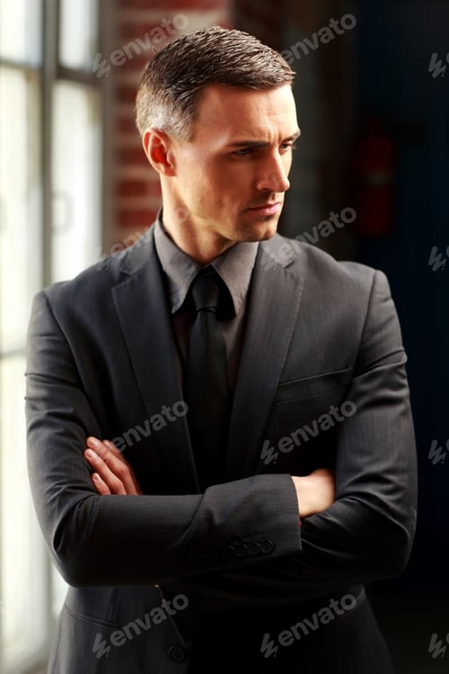 Preview: Pensive Businessman Standing With Arms Folded
