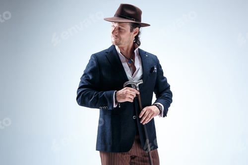 Preview: The Mature Man In A Suit And Hat Holding Cane.