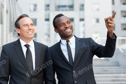 Preview: Showing The Opportunities. Two Cheerful Business Men Talking And Gesturing While Standing Outdoors