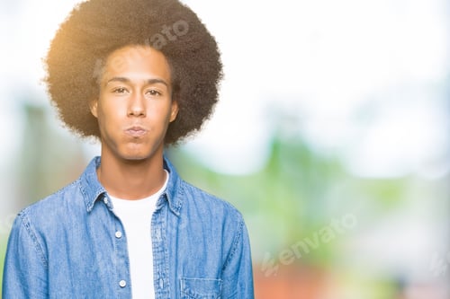 Preview: Young African American Man With Afro Hair Puffing Cheeks With Funny Face. Mouth Inflated With Air