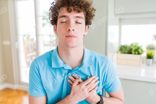 Preview: Young Handsome Man Wearing Casual Blue T-Shirt At Home Smiling With Hands On Chest With Closed Eyes