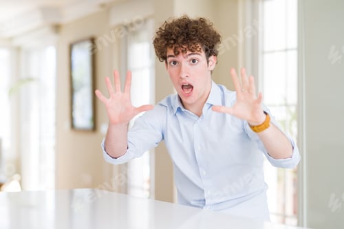 Preview: Young Business Man With Curly Read Head Afraid And Terrified With Fear Expression Stop Gesture With