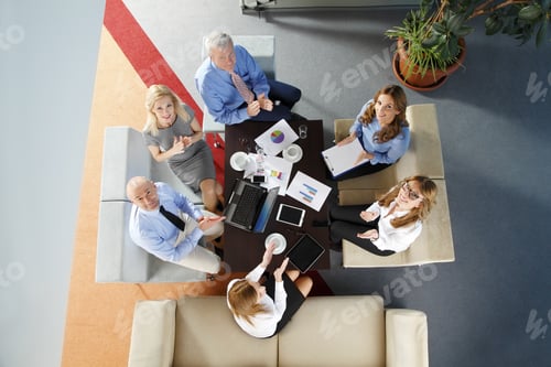 Preview: High Angle View Of Business People Sitting At Meeting. Executive Businesswoman Presenting Her Idea