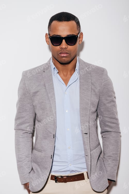 Preview: Stylish Handsome. Confident Young African Man In Sunglasses Holding Hands In Pockets And Looking At
