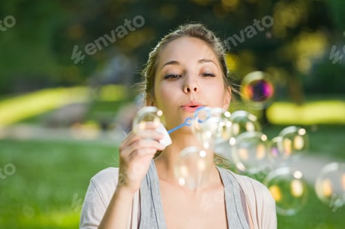 Preview: As Easy As Blowing Bubbles, Beautiful Young Brunette Making Soap Bubbles Outdoors.