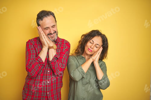 Preview: Beautiful Middle Age Couple Over Isolated Yellow Background Sleeping Tired Dreaming And Posing With
