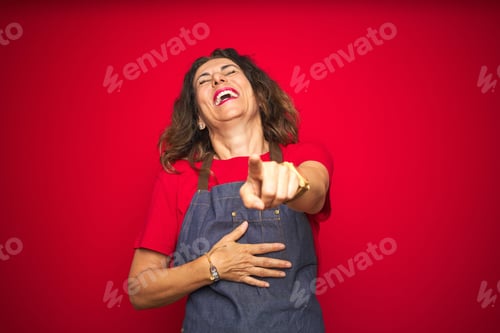 Preview: Middle Age Senior Woman Wearing Apron Uniform Over Red Isolated Background Laughing At You
