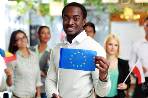 Preview: Happy African Businessman Holding Flag Of Usa In Front Of Colleagues
