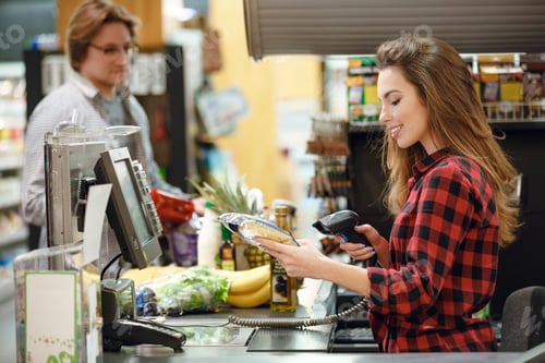 Preview: Image Of Happy Cashier Woman On Workspace In Supermarket Shop. Looking Aside.