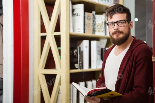 Preview: Handsome Boy With Beard In Brown Hoodie And Glasses Reading Book