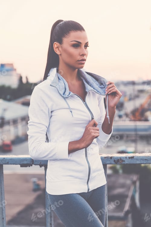 Preview: Sports Style. Beautiful Young Woman Adjusting Her Sports Clothes And Looking Away While Standing On