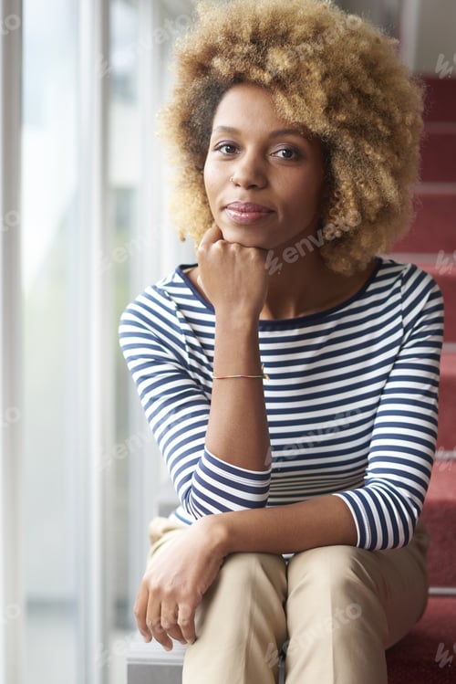 Preview: A Smiling Young Afro-American Woman Looking At Camera And Smiling To You While Sitting On Stairs