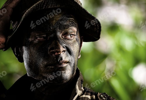 Preview: Portrait Of Young Soldier Face Painted With Jungle Camouflage In The Jungle