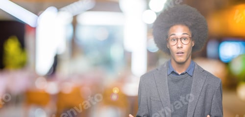 Preview: Young African American Business Man With Afro Hair Wearing Glasses Afraid And Shocked With Surprise