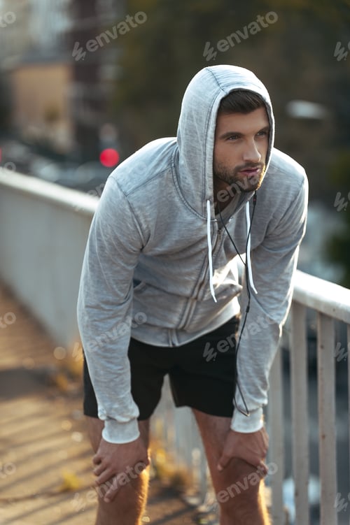 Preview: Breathe Deep And Keep On Running. Tired Young Man Resting After Running While Standing Outdoors