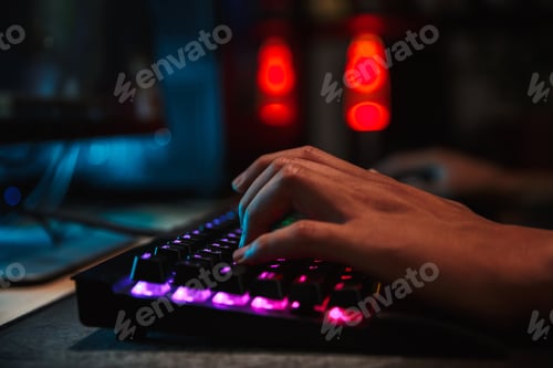 Preview: Hands Of Professional Gamer Boy Playing Video Games On Computer In Dark Room Using Backlit Colorful