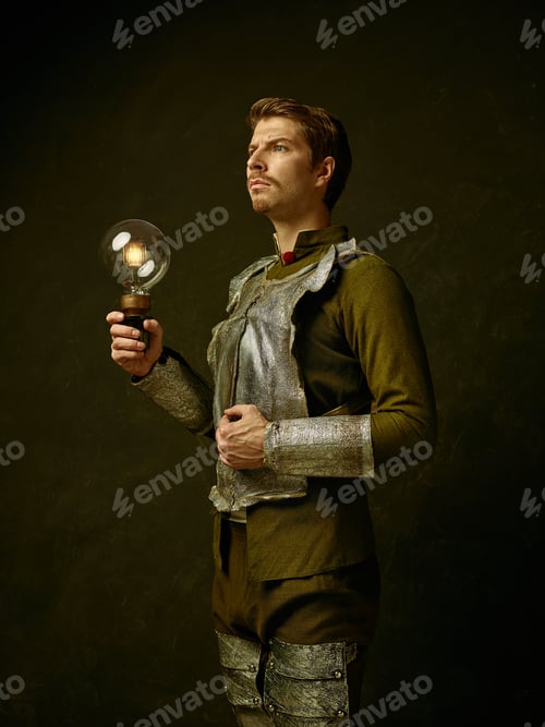 Preview: Medieval Knight With Lamp On Dark Studio Background. Portrait In Low Key Of Brutal Man In
