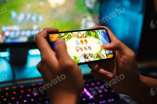 Preview: Hands Of Young Gamer Boy Playing Video Games On Smartphone And Computer In Dark Room Wearing