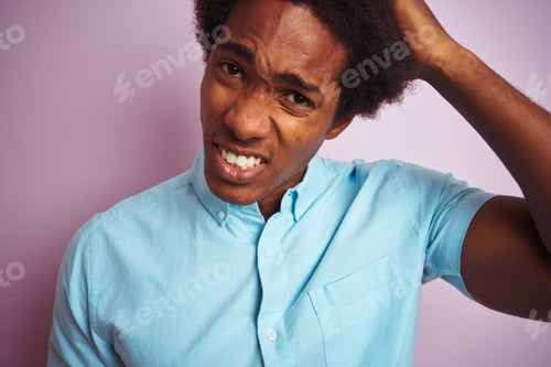 Preview: Young American Man With Afro Hair Wearing Blue Shirt Standing Over Isolated Pink Background