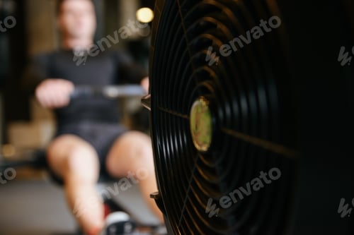 Preview: Muscular Man Which Using Rowing Machine In Gym. Focus On The Rowing Machine