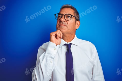 Preview: Handsome Middle Age Businessman Wearing Glasses Standing Over Isolated Blue Background Serious Face