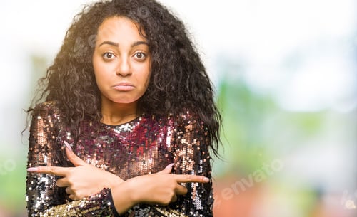 Preview: Young Beautiful Girl With Curly Hair Wearing Night Party Dress Pointing To Both Sides With Fingers