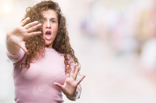 Preview: Beautiful Brunette Curly Hair Young Girl Wearing Pink Sweater Over Isolated Background Afraid And
