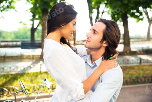 Preview: Happy Young Couple Hugging Outdoors And Looking At Each Other