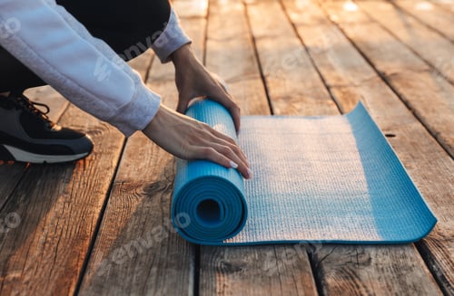 Preview: Close Up Of A Woman Unwrapping Fitness Mat Outdoors