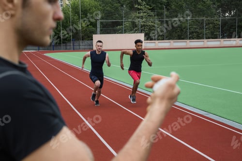 Preview: Image Of Young Multiethnic Athlete Men Run On Running Track Outdoors. Historic Stop Watch Time
