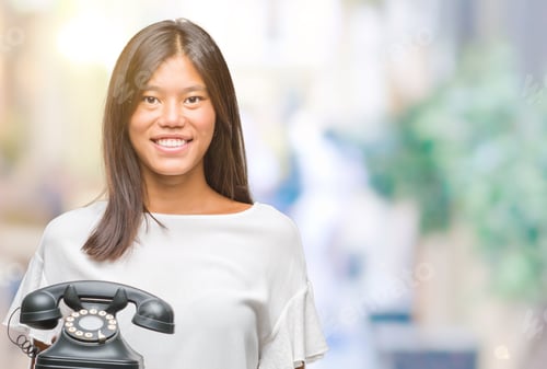 Preview: Young Asian Woman Holding Vintagera Telephone Over Isolated Background With A Happy Face Standing