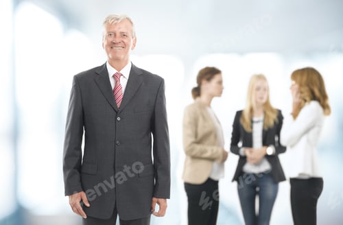 Preview: Senior Businessman Standing With Colleagues At Office. Teamwork.