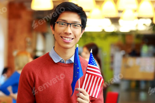 Preview: Happy Asian Boy In Glasses Holding Flag Of Europe Union And Usa