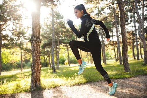 Preview: Beautiful Fit Sportswoman Doing Warming Up Exercises Before Jogging At The Park, Jumping, Listening