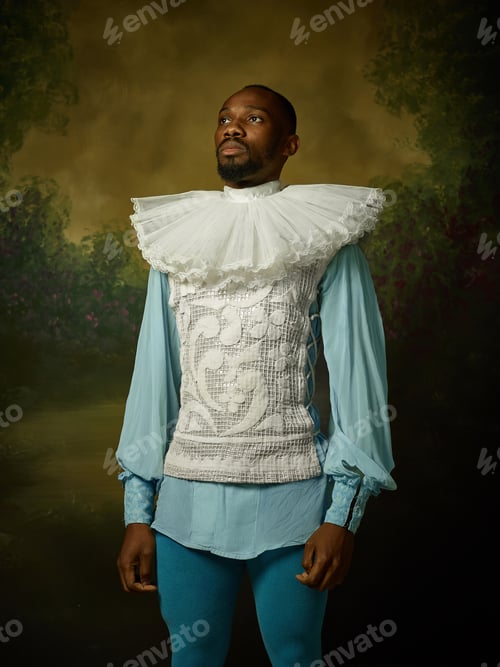 Preview: Young Man As A Medieval Grandee Or Nobleman On Dark Studio Background. Looking Serious. Portrait Of
