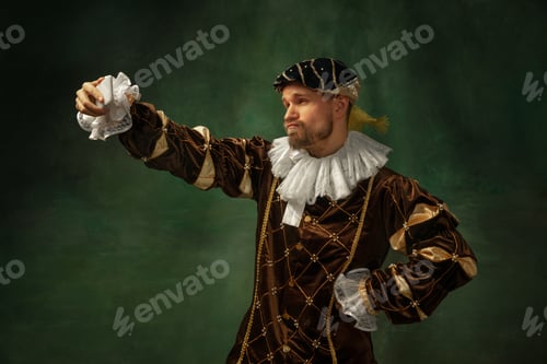 Preview: King'S Self-Portrait. Portrait Of Medieval Young Man In Vintage Clothing With Smartphone On Dark