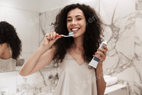 Preview: Photo Of Healthy Beautiful Woman With Long Dark Hair Standing In Bathroom And Cleaning Teeth With