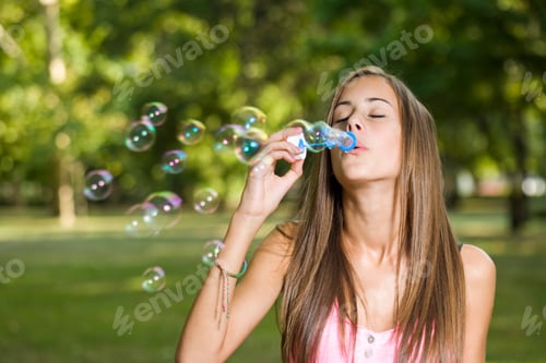 Preview: Portrait Of A Gorgeous Dreamy Young Teen Blowing Soap Bubbles.